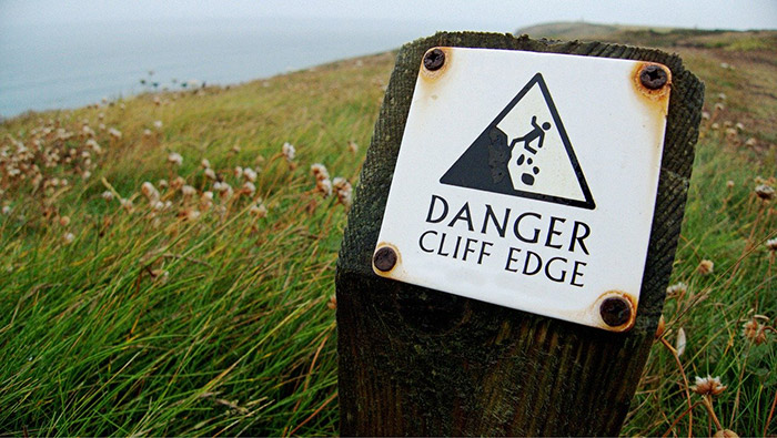 dangerous place sign on cliff