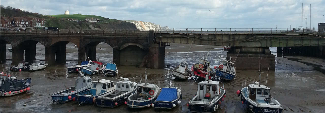 boats in folkestone harbour with the sea out